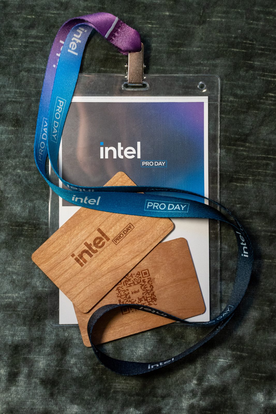 Wooden Intel Pro Day access keys with embossed logo and laser-etched QR code, resting on a branded lanyard badge